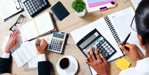 accountant preparing financial statement on paper using calculator